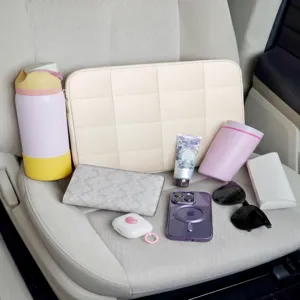 Quilted laptop sleeve detail showcasing soft puffer texture and daily lifestyle accessories in car.