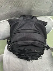 Black hiking backpack cycling daypack with front zipper pockets and elastic bungee cord mesh.