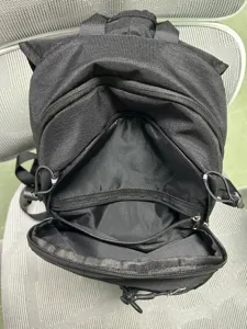 Detail view of the black hiking backpack interior, showing multiple zipper compartments and pockets.