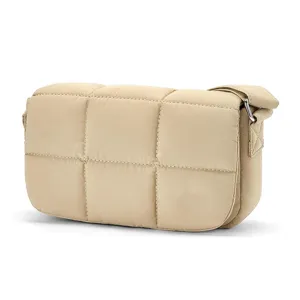 Detailed view of the beige quilted nylon crossbody bag featuring soft padded texture.
