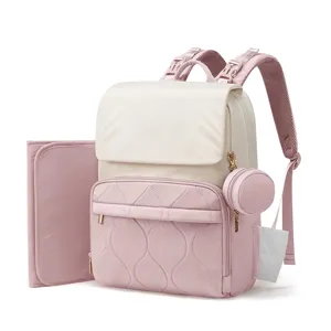Détail du sac à dos à langer matelassé rose avec tissu doux, tapis de change et pochette assortie.