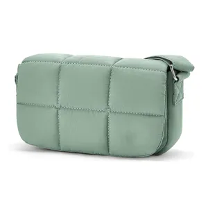 Detail view of a small sage green quilted nylon crossbody bag with puffy cloud design.