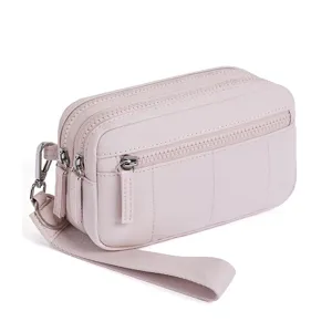 Close-up detail of the pink multi-zipper wristlet wallet, showing zippers and wrist strap.