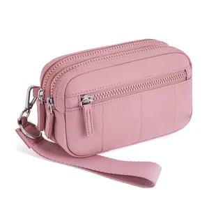 Pink nylon quilted wrist wallet phone bag with multiple zipper compartments and hand strap.