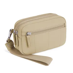 Beige nylon multi-zipper wrist wallet detail, compact phone pouch with wrist strap.