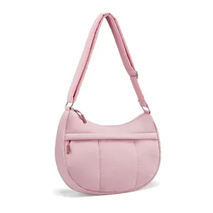 Detail of the pink nylon quilted crescent shoulder bag featuring adjustable strap.