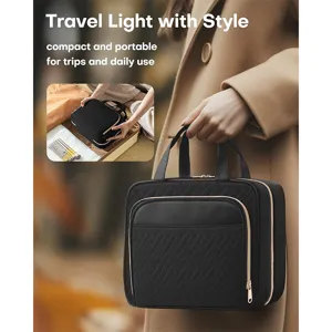 Black quilted travel cosmetic bag with portable handle and gold zipper for daily use and trips.