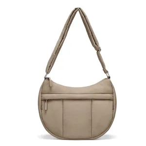 Small quilted nylon crescent shoulder bag with adjustable strap and front zipper pocket for women.