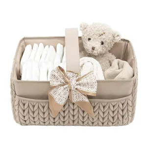 Panier organisateur de couches pour bébé avec poignées, ours en peluche et compartiments de rangement.