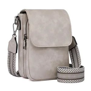 Detailed view of grey PU leather crossbody bag, stylish geometric strap, metal hardware.