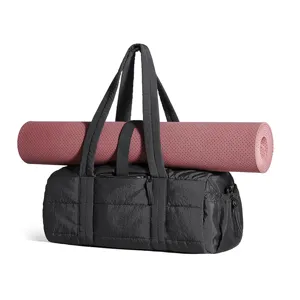 Detailed view of women puffy quilted gym duffel bag in black with integrated pink yoga mat.
