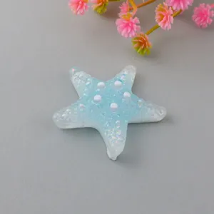 Detailed close-up shot of a gradient blue resin starfish charm featuring pearl dots and glitter texture.