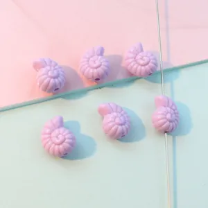 Close-up of pastel purple acrylic conch shape beads, perfect for DIY jewelry crafting.