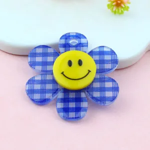 Dettaglio ciondolo girasole in acrilico a quadri blu con smiley per creazione di gioielli fai da te.