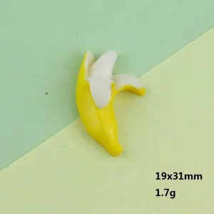 Vista dettaglio ciondolo banana semi sbucciata in resina, accessorio gioiello carino.