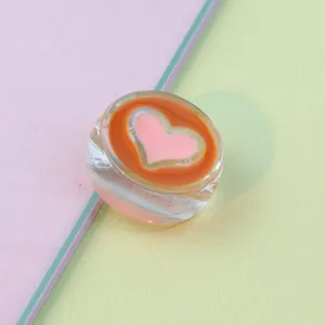 Transparent acrylic heart bead detail, pink and orange inner pattern, DIY accessory.