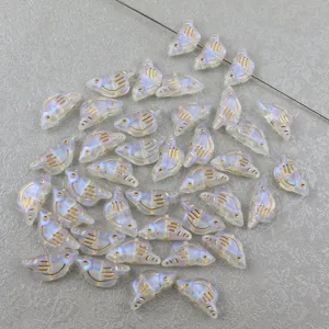 Acrylic bird loose beads detail shot, showing gold painted lines and iridescent finish.