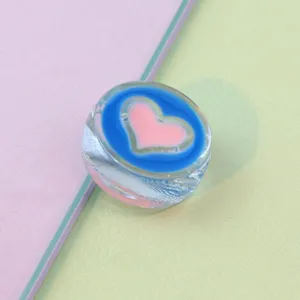 Close-up view of the 21mm clear round acrylic bead featuring a lovely blue and pink heart pattern.