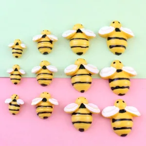 Close-up detail of cute resin bumblebee flatback charms in various sizes for DIY crafts.