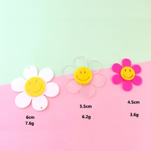 Close-up detail of acrylic smiley flower pendant charms, showing size, weight and texture.