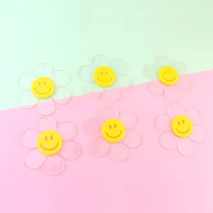 Clear glitter acrylic flower pendants with yellow smiley face center detail view.