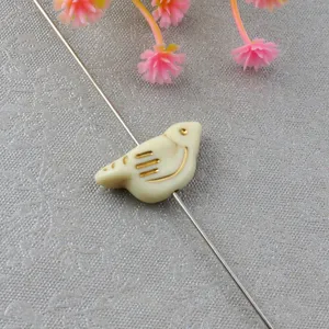 Detailed close-up of a vintage gold-trimmed acrylic bird loose bead for DIY jewelry making.