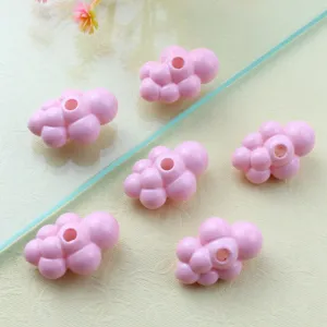 Close-up detail of cute pink acrylic cloud beads for DIY jewelry making accessories.