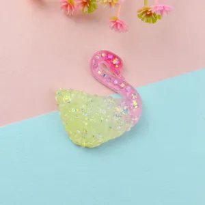 Close-up of iridescent gradient glitter swan resin patch for DIY handmade phone case decor.