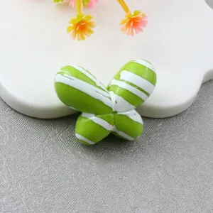 Green and white striped fat butterfly bead detail shot, perfect for DIY phone charms and jewelry making.
