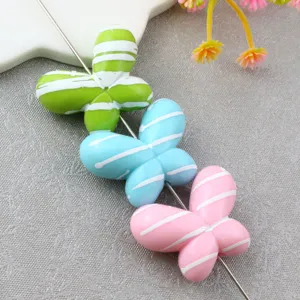 Close-up of colorful striped butterfly loose beads for DIY jewelry and phone chains.