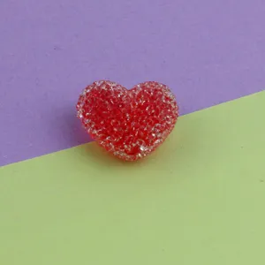 Red heart acrylic sugar bead DIY jewelry accessory close up showing sparkling textured detail.