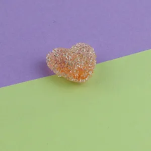 Close-up detail of sparkling acrylic sugar heart bead, perfect for DIY jewelry crafting.