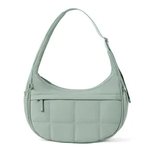 Detail view of the sage green quilted hobo shoulder bag with grid stitching and front pocket.
