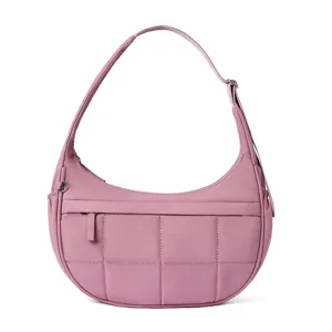 Close-up view of the pink quilted shoulder bag showing soft puffy fabric texture and fine stitching detail.