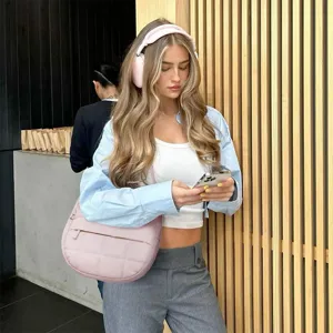 Detail view of the stylish pink quilted shoulder bag lifestyle matching with casual outfit.