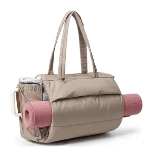 Detail shot of beige quilted puffer tote bag with yoga mat holder and spacious design.