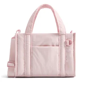 Pink puffer tote bag detail, lightweight quilted crossbody handbag with sturdy handles.
