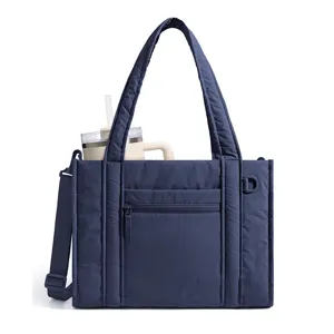 Dark blue quilted tote bag detail view, featuring a spacious interior and front pocket.
