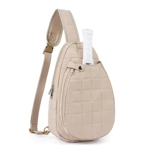 Detailed close-up view of beige quilted tennis sling bag featuring adjustable strap and racket slot.