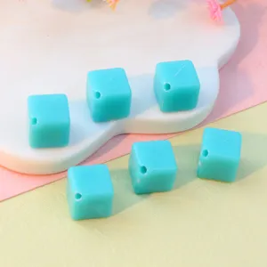 Close-up of 8mm diagonal hole turquoise acrylic square beads, ideal for DIY jewelry parts.