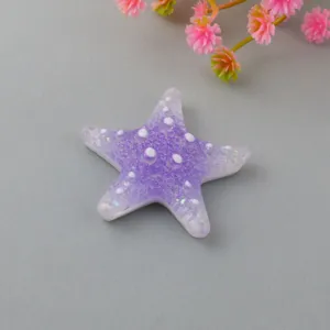 Close-up detail of gradient purple glitter starfish resin accessory, DIY craft patch component.