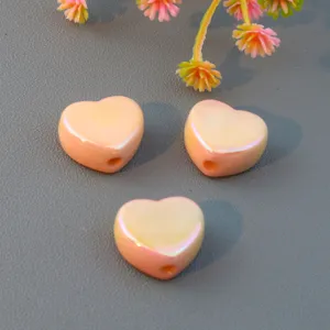 Close-up detail of smooth peach heart beads, macaron color straight hole loose beads DIY accessory.