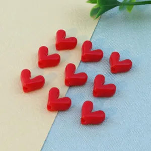 Red heart-shaped loose beads detail close-up, perfect for DIY jewelry making crafts.