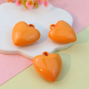 Detailed view of 27mm orange glossy heart pendant charms for DIY jewelry and keychain making.