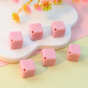 Pink acrylic diagonal hole cube beads close-up, perfect for DIY jewelry and phone chain making.