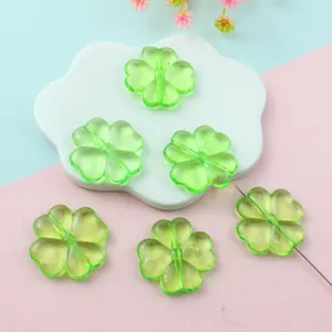 Green four-leaf clover acrylic beads detail shot showing transparent texture and hole for jewelry.