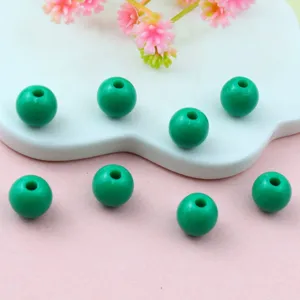 Close-up detail of green acrylic loose round beads for DIY jewelry making and crafting.