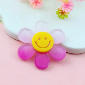 Primo piano dettagliato del ciondolo di fiore in acrilico rosa con simpatica faccia smiley.