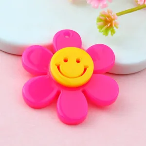 Ciondolo girasole in acrilico rosa con charm viso smiley giallo per creazioni di bigiotteria.
