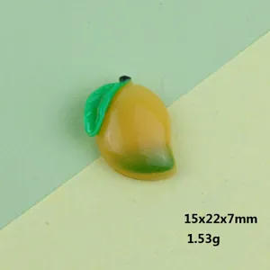 Primo piano dettagliato di un simpatico cabochon in resina a forma di mango per creazioni fai da te.